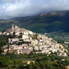 Borgo medievale arroccato su una collina, con case in pietra e una torre campanaria. Un luogo incantevole dove scoprire cosa vedere a Trevi.