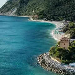 Ancona mare: una baia con spiaggia attrezzata, torre medievale e mare cristallino.