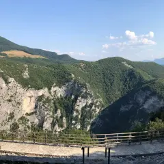 Panoramica mozzafiato dalla terrazza del Furlo, con rocce imponenti e colline verdi sotto un cielo azzurro.