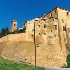 Fortificazioni imponenti e un campanile svettano nel cielo azzurro di Serra de' Conti, un borgo storico che incanta.