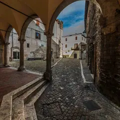 Arco medievale con vista su vicolo lastricato e case antiche. Un assaggio di cosa vedere a Narni, tra storia e fascino.