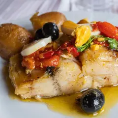 Stoccafisso all'Anconetana con patate, olive nere, pomodorini e uovo sodo. Un piatto ricco e saporito.