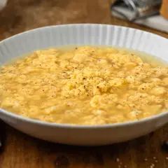 Stracciatella in brodo marchigiana, un piatto confortante con uova strapazzate in brodo, pepe nero e un tocco di formaggio grattugiato.