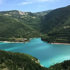 Splendido lago di Fiastra con acque turchesi, incastonato tra montagne verdi e rigogliose.