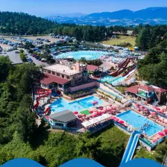 Vasta area con piscine, scivoli e ombrelloni rossi, immersa nel verde delle colline. Un divertente parco acquatico nelle Marche per tutta la famiglia.