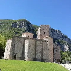 Genga, cosa vedere: l'antica Abbazia di San Vittore, un gioiello romanico incastonato tra montagne verdi e un cielo azzurro.