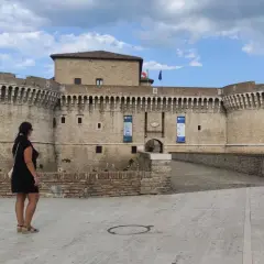 Una donna ammira la Rocca Roveresca, un gioiello da scoprire tra le cose da vedere a Senigallia e dintorni.