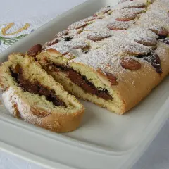 Ciambellone marchigiano con ripieno goloso di Nutella, decorato con mandorle e zucchero a velo.