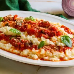 Frascarelli ricetta originale: un piatto cremoso con sugo di pomodoro, verdure e parmigiano, guarnito con basilico fresco.