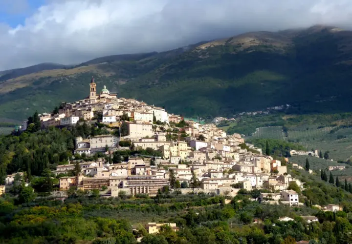 Borgo medievale arroccato su una collina, con case in pietra e una torre campanaria. Un luogo incantevole dove scoprire cosa vedere a Trevi.