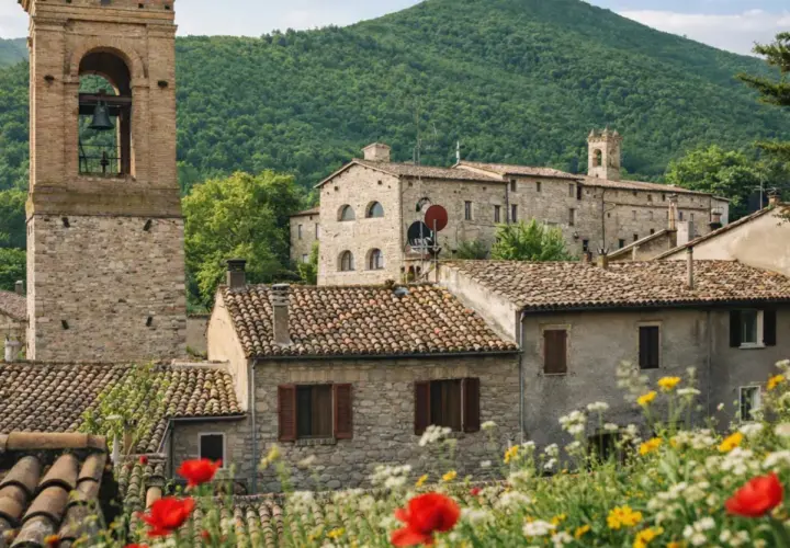 Esanatoglia cosa vedere: borgo medievale con torre campanaria, case in pietra e fiori colorati.