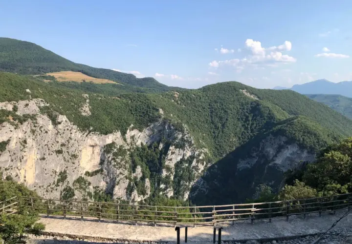 Panoramica mozzafiato dalla terrazza del Furlo, con rocce imponenti e colline verdi sotto un cielo azzurro.