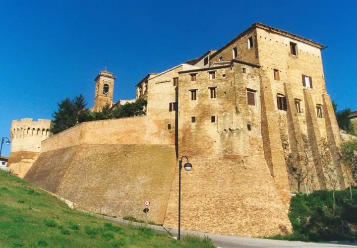 Fortificazioni imponenti e un campanile svettano nel cielo azzurro di Serra de' Conti, un borgo storico che incanta.