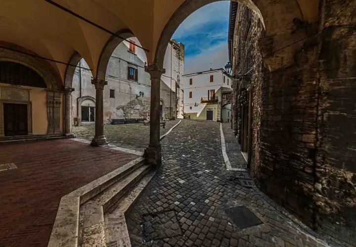 Arco medievale con vista su vicolo lastricato e case antiche. Un assaggio di cosa vedere a Narni, tra storia e fascino.