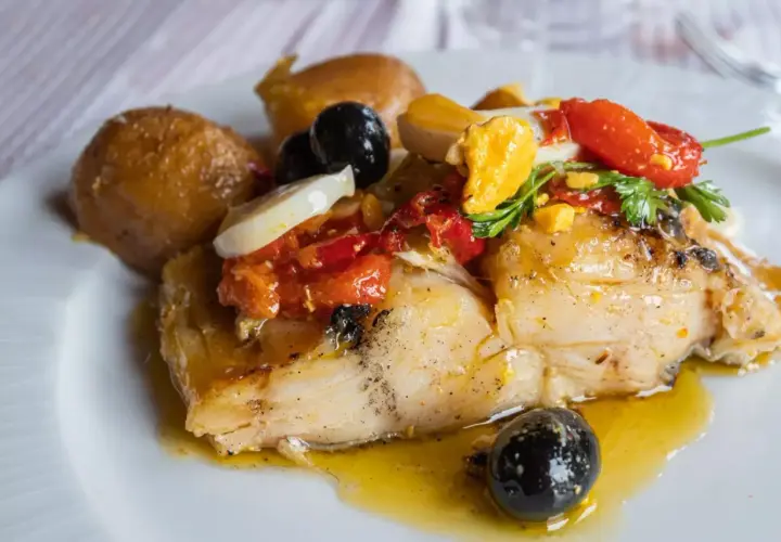 Stoccafisso all'Anconetana con patate, olive nere, pomodorini e uovo sodo. Un piatto ricco e saporito.