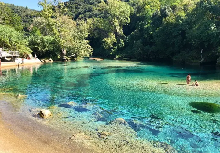 Acque cristalline e natura rigogliosa allo **stifone Mole di Narni**. Persone si godono il sole e il fresco in questo paradiso naturale.