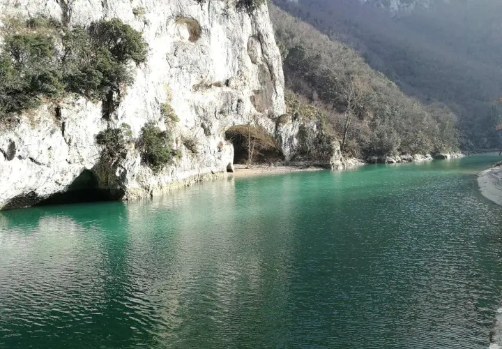 Acqualagna cosa vedere: un lago smeraldo incastonato tra imponenti pareti rocciose con grotte naturali.