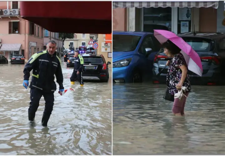 Uomini in divisa e una donna con ombrello camminano nell'acqua alta. Ecco cosa fare a San Benedetto del Tronto se piove: cercare riparo.