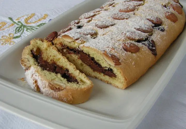 Ciambellone marchigiano con ripieno goloso di Nutella, decorato con mandorle e zucchero a velo.