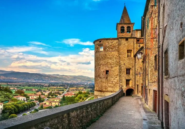 Un vicolo storico con un torrione medievale e una vista panoramica sulla valle. Perfetto per scoprire le cose da fare a Anghiari.