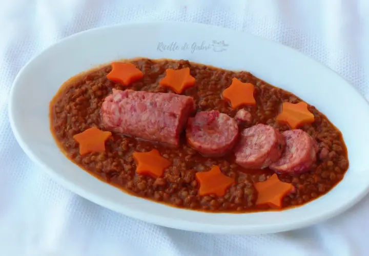 Piatto di lenticchie e cotechino alla marchigiana, decorato con stelline di carota. Un classico saporito e invitante.