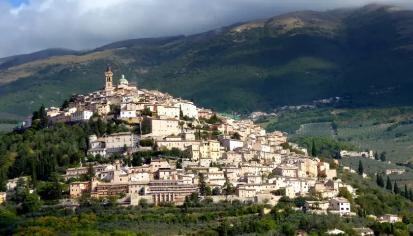Borgo medievale arroccato su una collina, con case in pietra e una torre campanaria. Un luogo incantevole dove scoprire cosa vedere a Trevi.