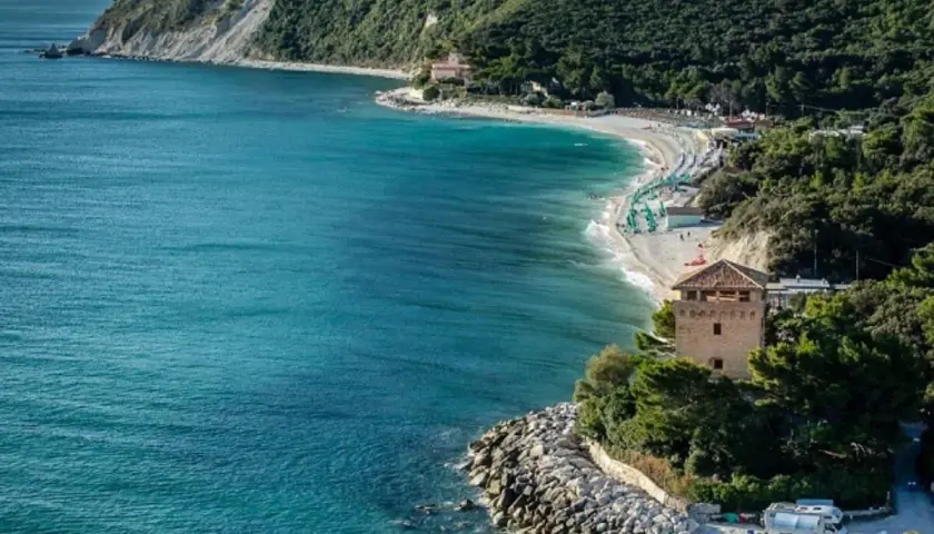 Ancona mare: una baia con spiaggia attrezzata, torre medievale e mare cristallino.