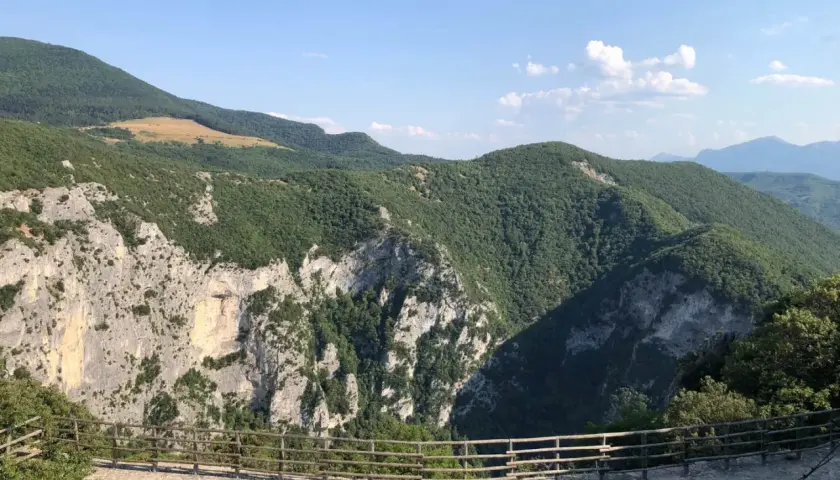 Panoramica mozzafiato dalla terrazza del Furlo, con rocce imponenti e colline verdi sotto un cielo azzurro.