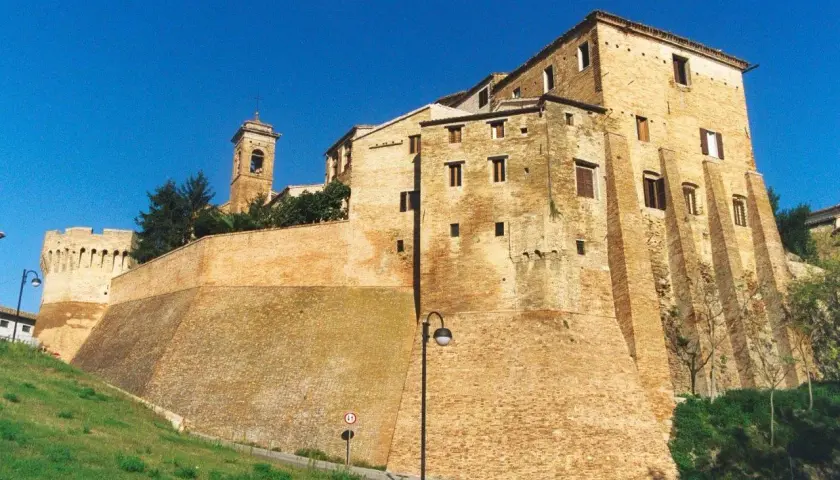 Fortificazioni imponenti e un campanile svettano nel cielo azzurro di Serra de' Conti, un borgo storico che incanta.