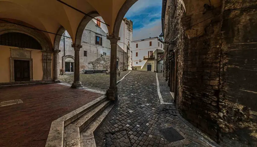 Arco medievale con vista su vicolo lastricato e case antiche. Un assaggio di cosa vedere a Narni, tra storia e fascino.