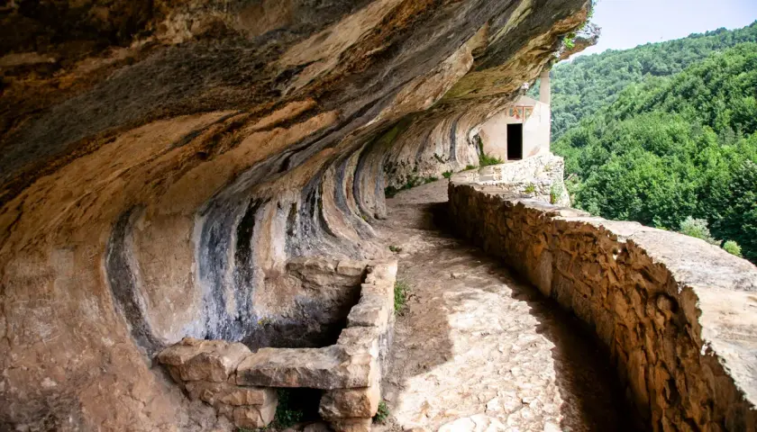 Sentiero roccioso verso l'eremo di San Bartolomeo, incastonato nella roccia con vista su boschi rigogliosi. Come arrivare?