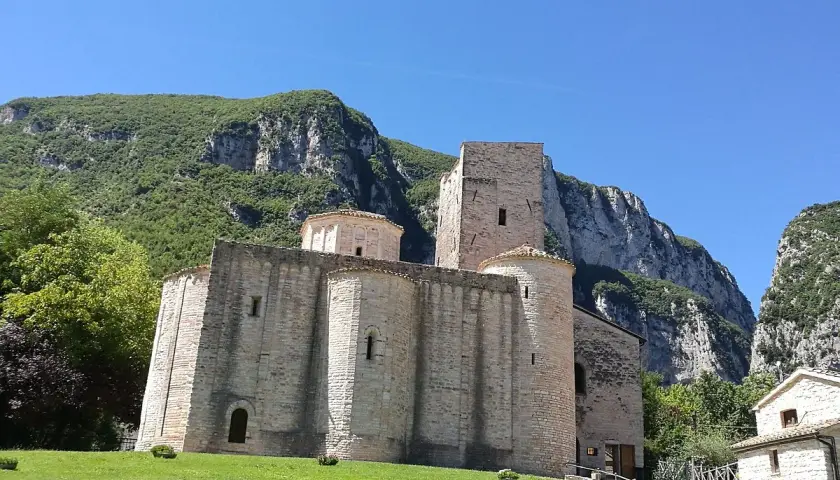 Genga, cosa vedere: l'antica Abbazia di San Vittore, un gioiello romanico incastonato tra montagne verdi e un cielo azzurro.