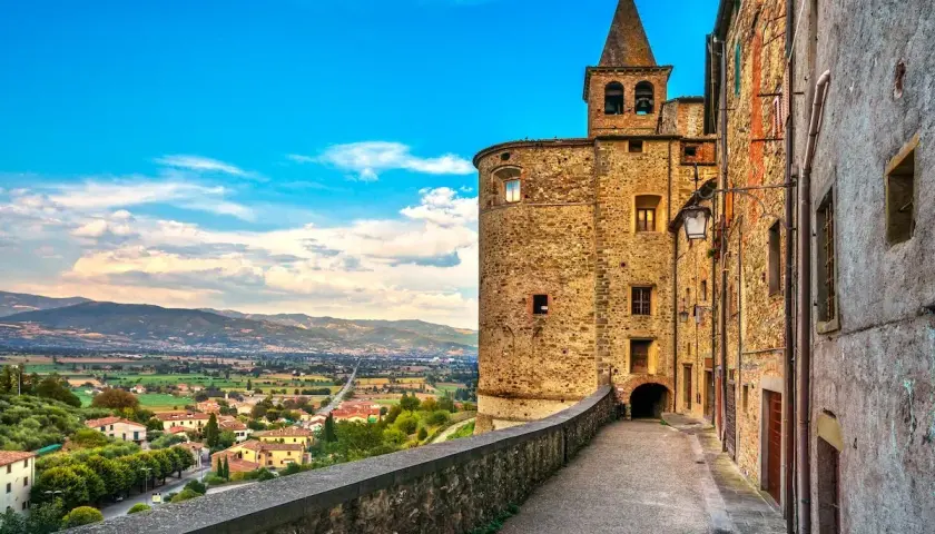 Un vicolo storico con un torrione medievale e una vista panoramica sulla valle. Perfetto per scoprire le cose da fare a Anghiari.