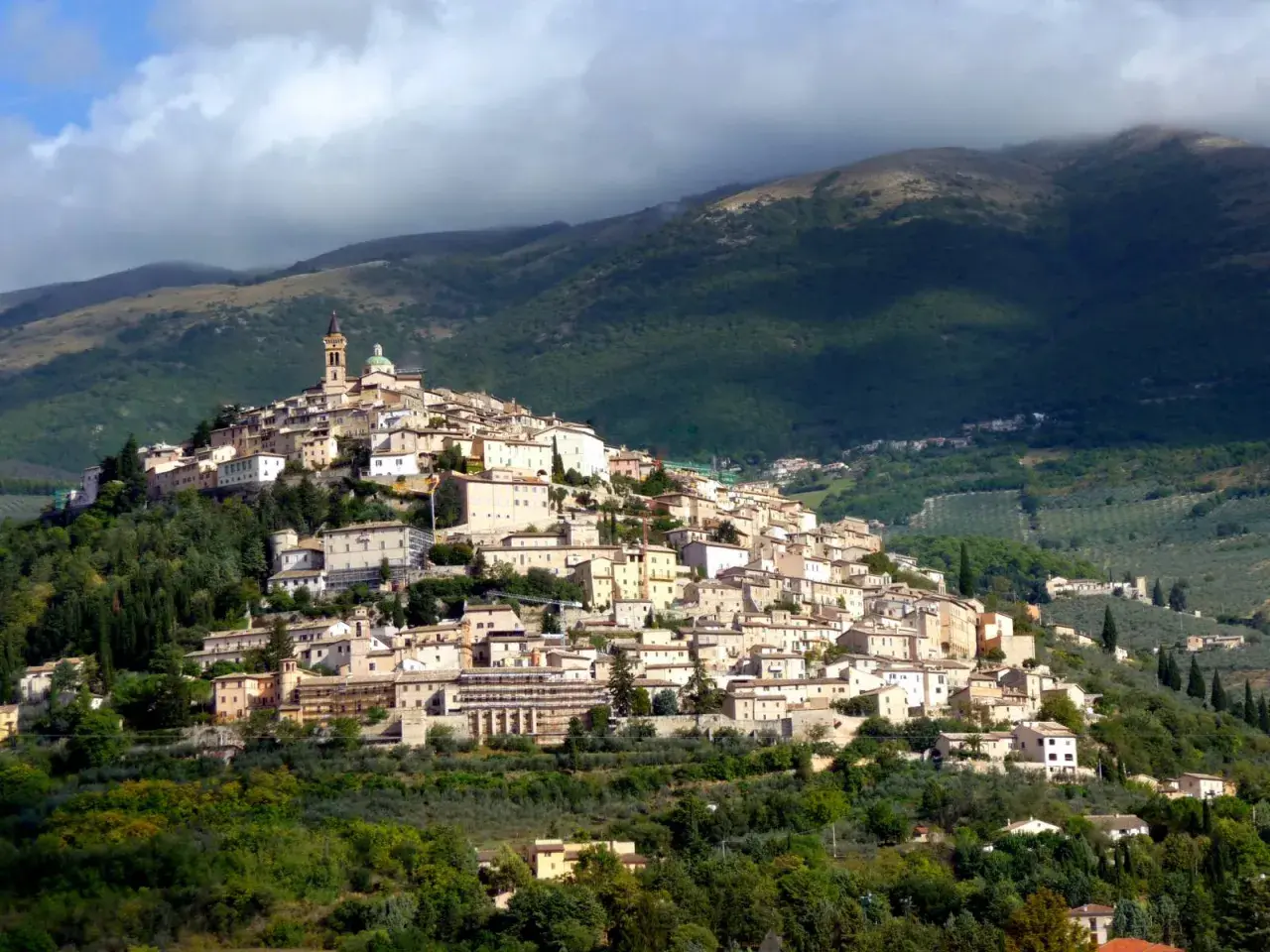 Borgo medievale arroccato su una collina, con case in pietra e una torre campanaria. Un luogo incantevole dove scoprire cosa vedere a Trevi.