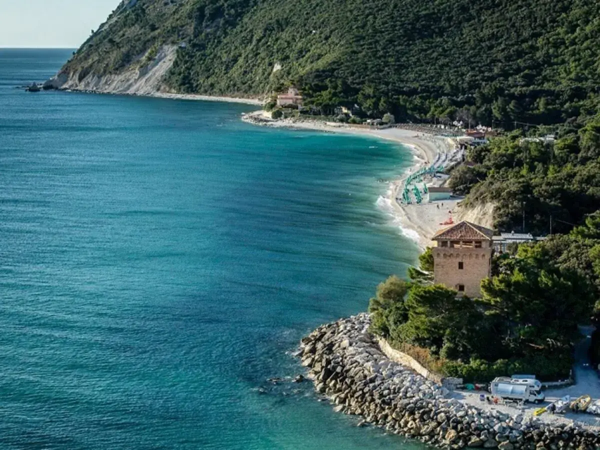 Ancona mare: una baia con spiaggia attrezzata, torre medievale e mare cristallino.