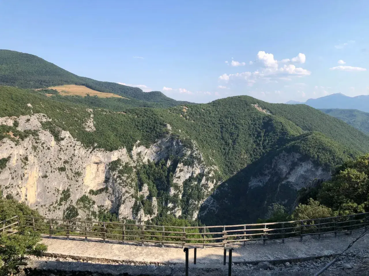 Panoramica mozzafiato dalla terrazza del Furlo, con rocce imponenti e colline verdi sotto un cielo azzurro.