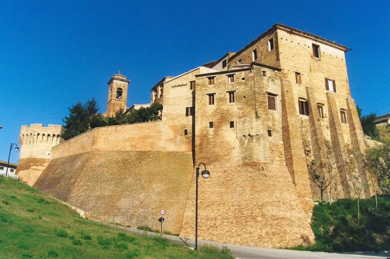 Fortificazioni imponenti e un campanile svettano nel cielo azzurro di Serra de' Conti, un borgo storico che incanta.