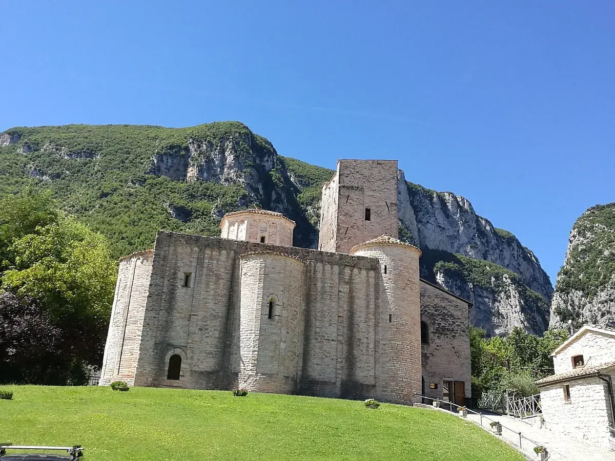 Genga, cosa vedere: l'antica Abbazia di San Vittore, un gioiello romanico incastonato tra montagne verdi e un cielo azzurro.