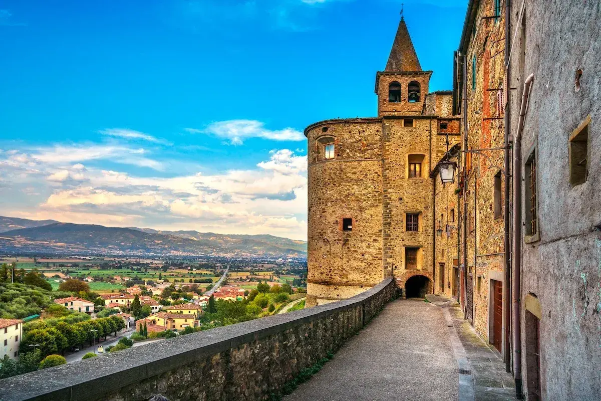 Un vicolo storico con un torrione medievale e una vista panoramica sulla valle. Perfetto per scoprire le cose da fare a Anghiari.