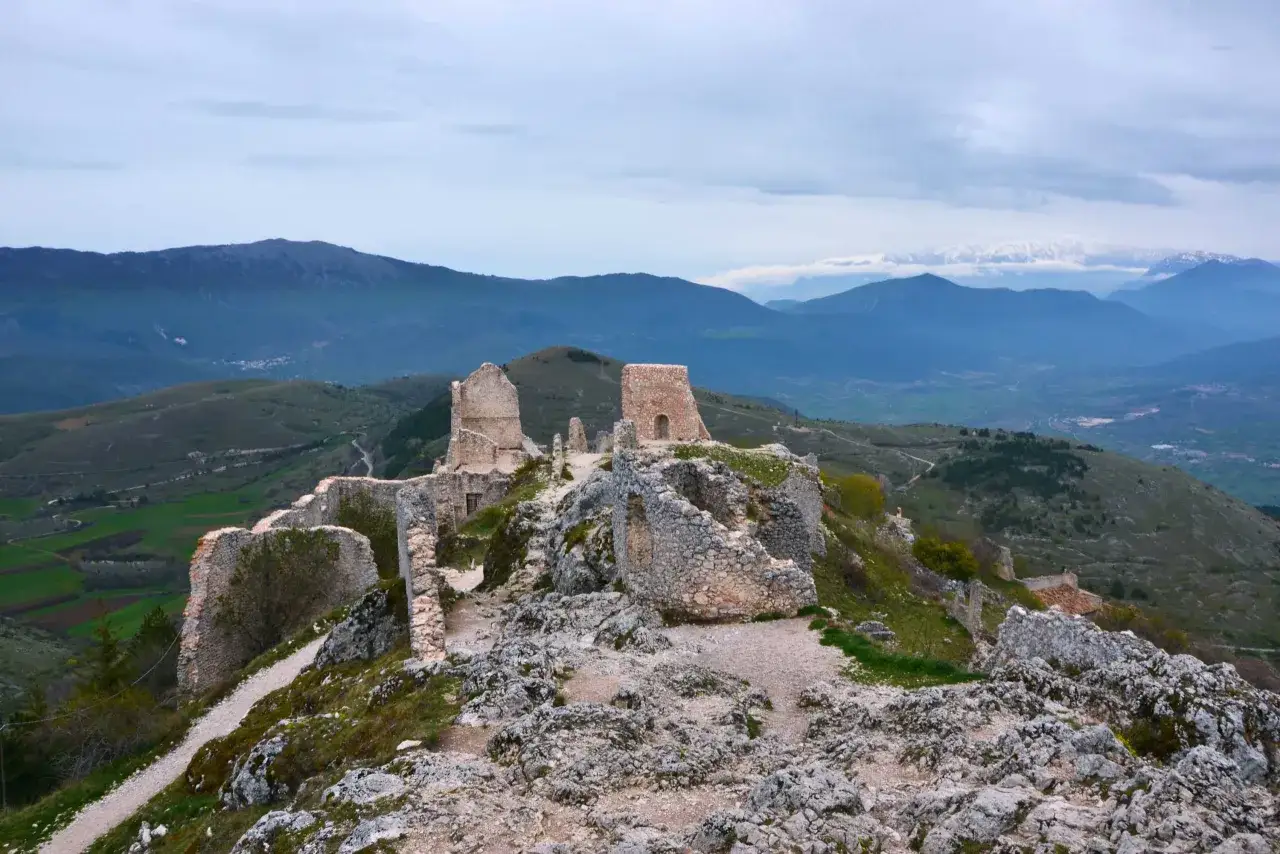 Rovine di un castello su una collina rocciosa, con montagne sullo sfondo. Un luogo suggestivo nel cuore del Santo Stefano d'Abruzzo.