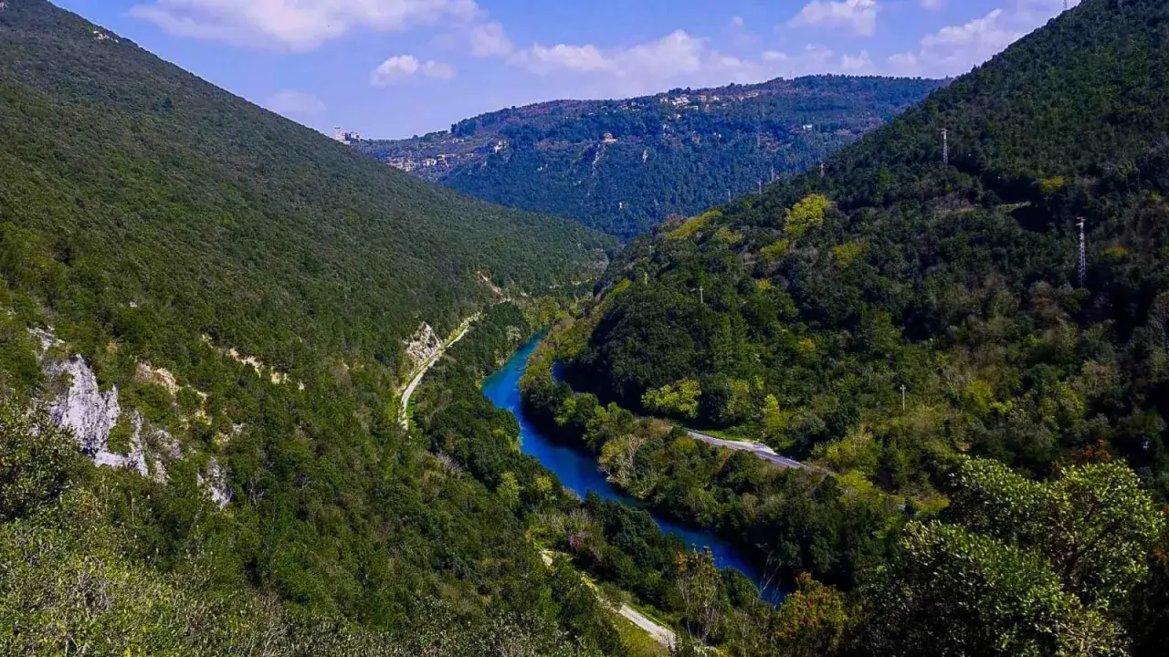 Stifone, Mole di Narni: un fiume blu serpeggia tra montagne verdi e alberate, con una strada che costeggia le sue rive.