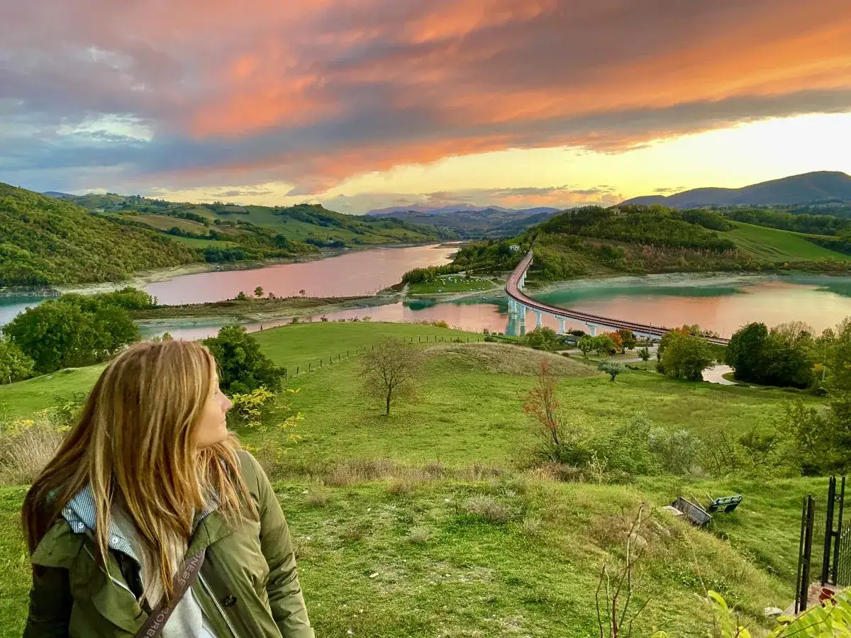 Tramonto mozzafiato sulla diga di Cingoli, con una donna che ammira il paesaggio.