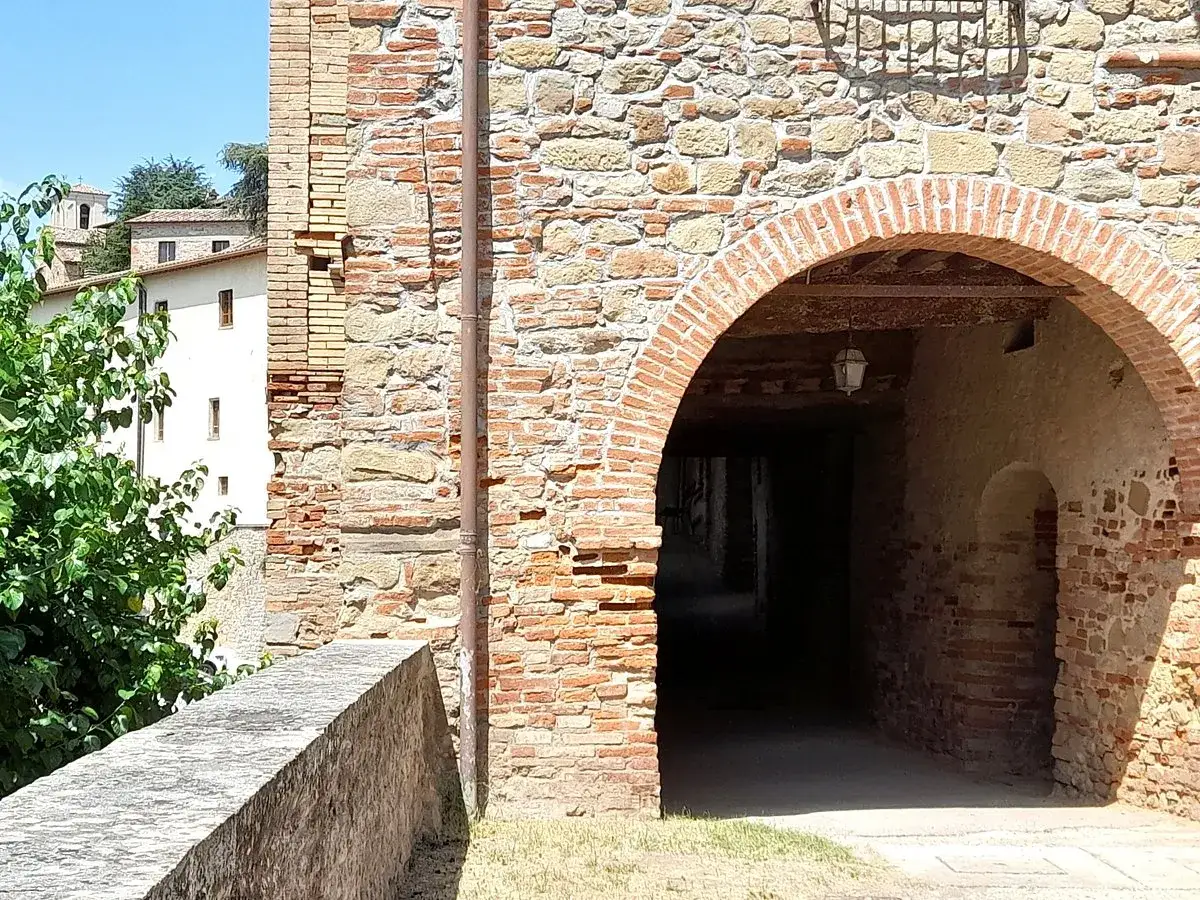 Un antico passaggio ad arco in mattoni rossi, con un'ombra invitante. Un luogo da esplorare, una citerna cosa vedere.