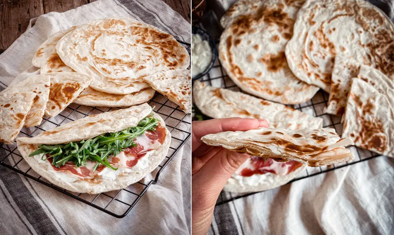 La crescia, soffice e dorata, farcita con formaggio cremoso, prosciutto e rucola, pronta per essere gustata.