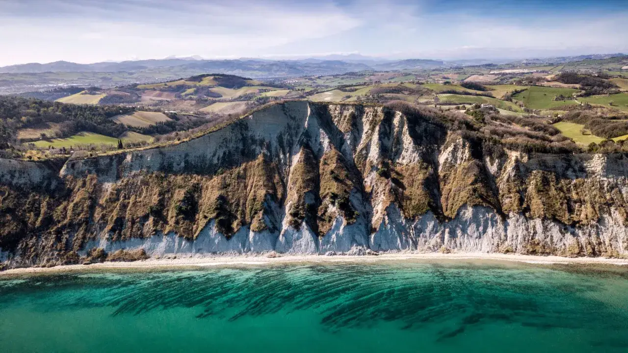 Scogliere a picco sul mare turchese, un paesaggio mozzafiato che invita a scoprire cosa vedere a Pesaro e dintorni.