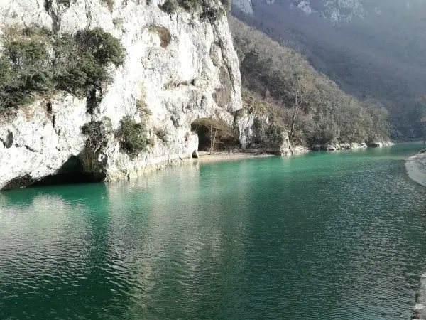 Acqualagna cosa vedere: un lago smeraldo incastonato tra imponenti pareti rocciose con grotte naturali.